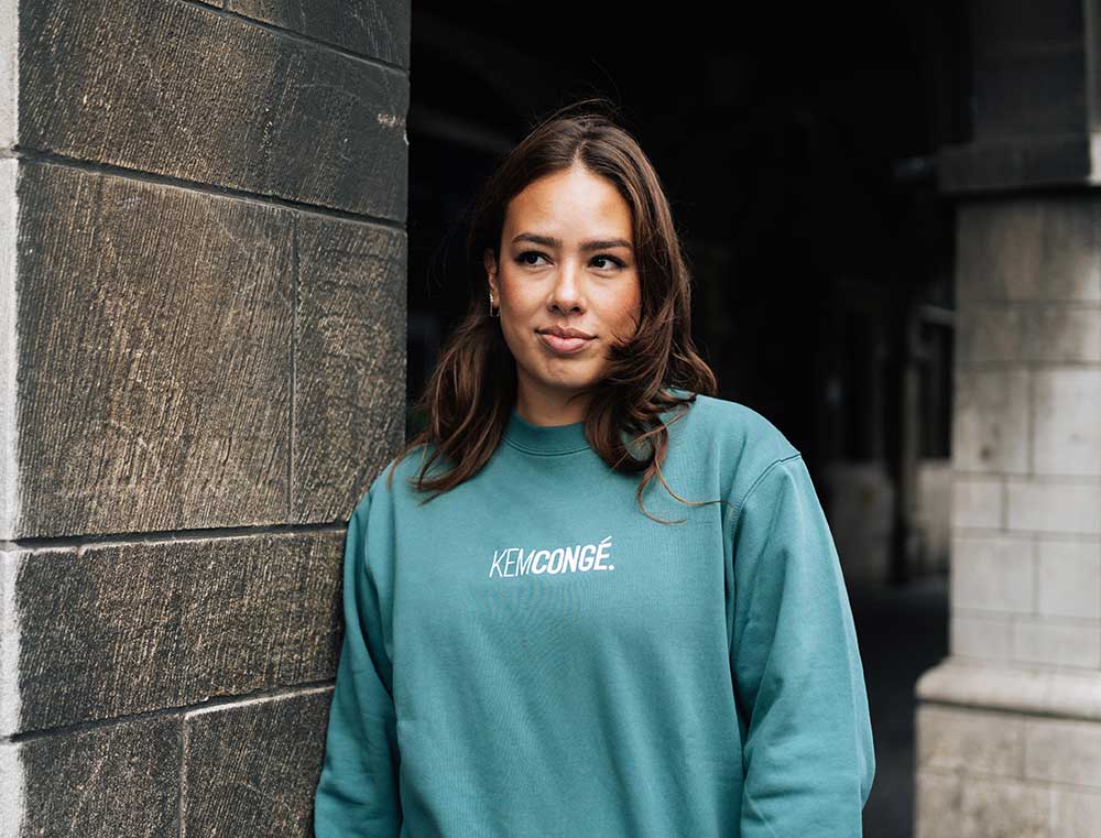 Vrouw met een groene sweater met opdruk KEMCONGE.