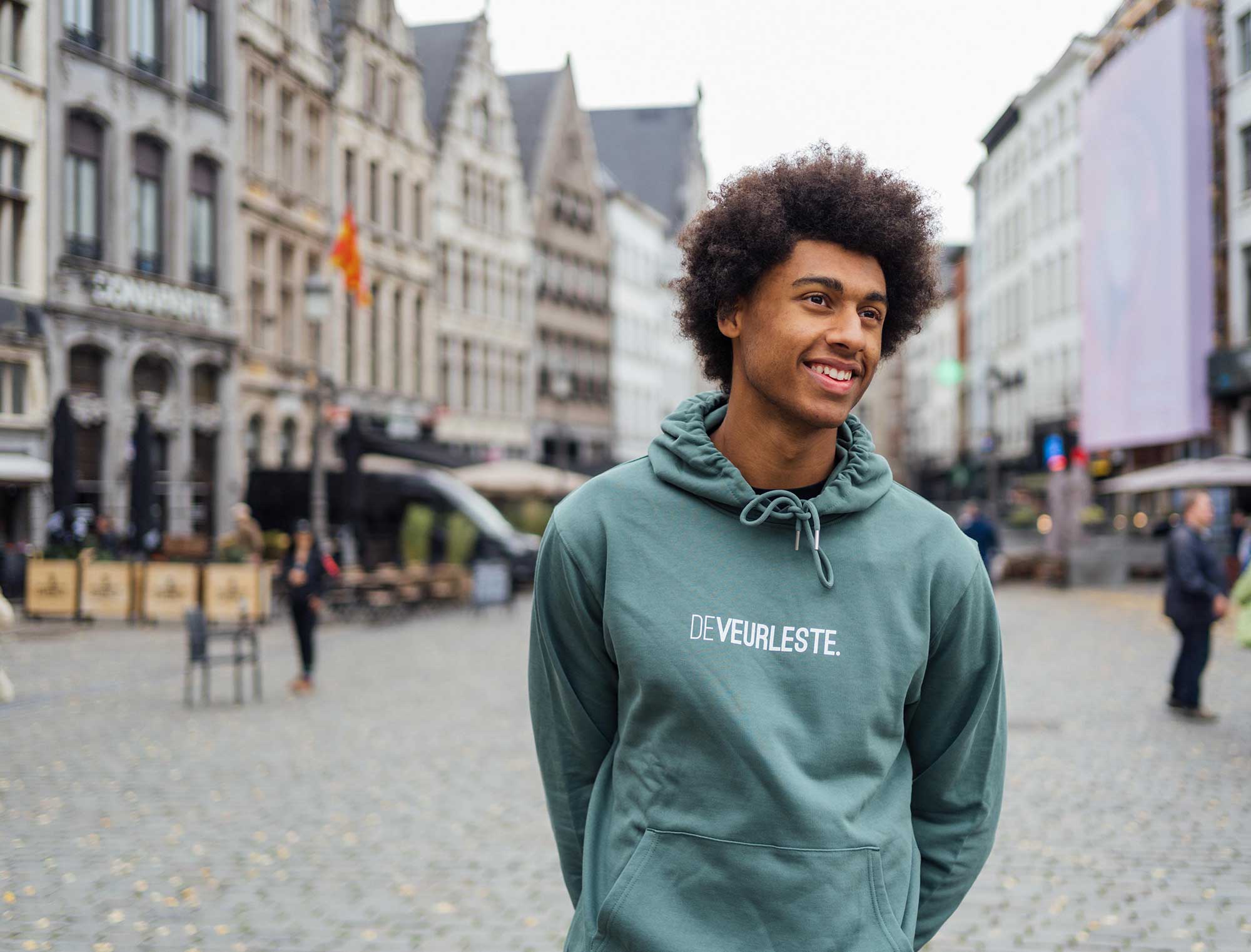 Man met groene hoodie met opdruk DEVEURLESTE.