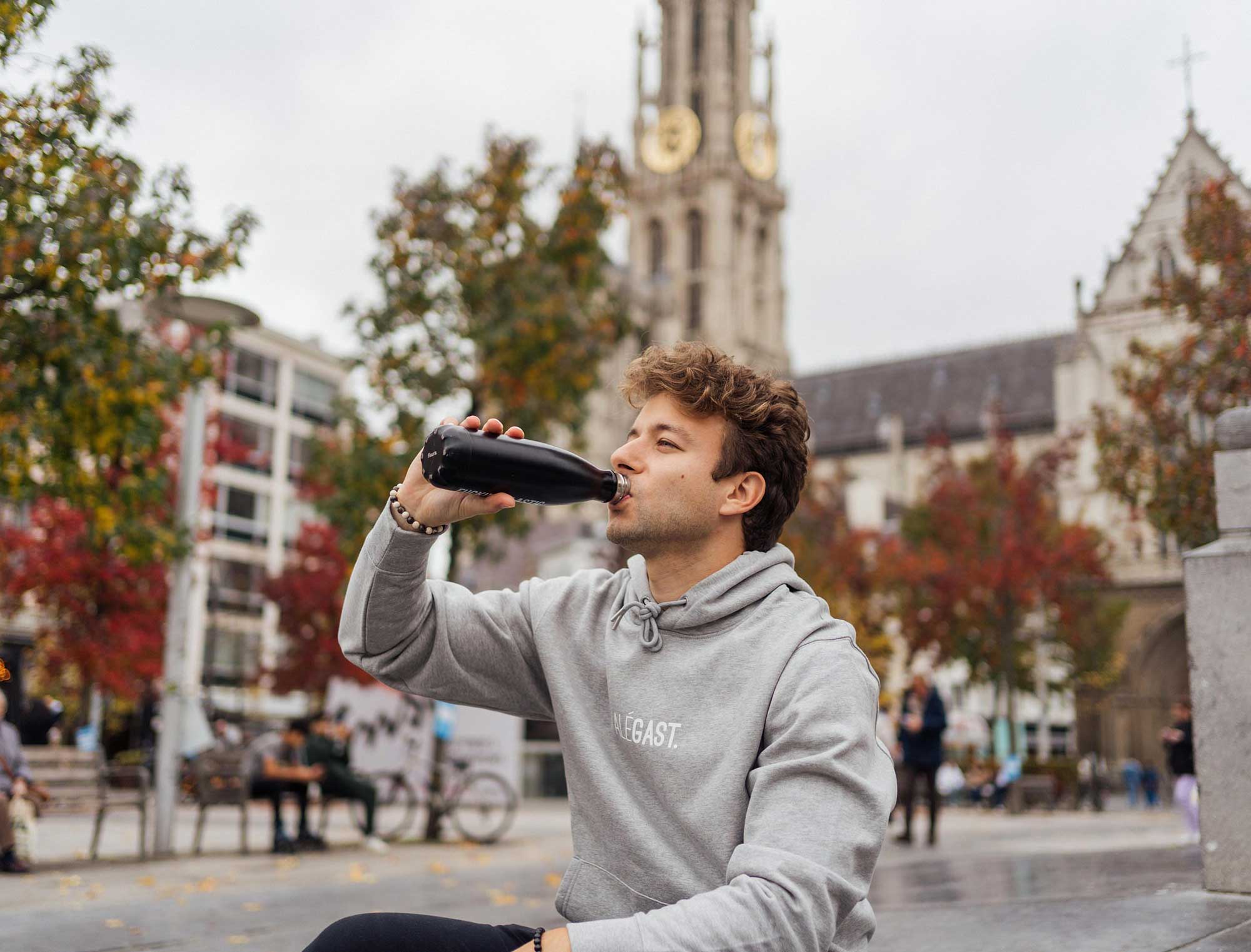 Man met grijze hoodie met opdruk ALEGAST.