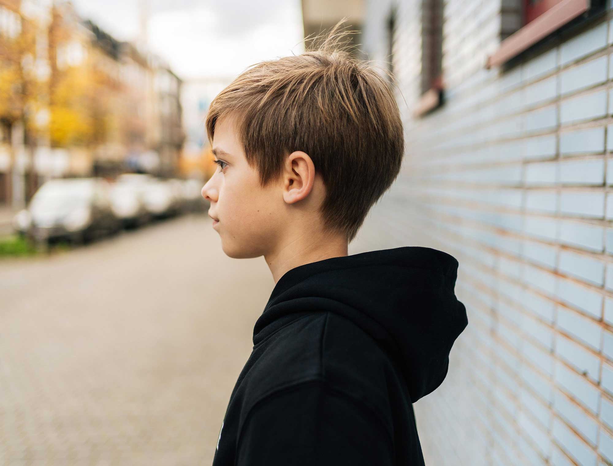 Jonge met een zwarte hoodie, met de focus op de kap