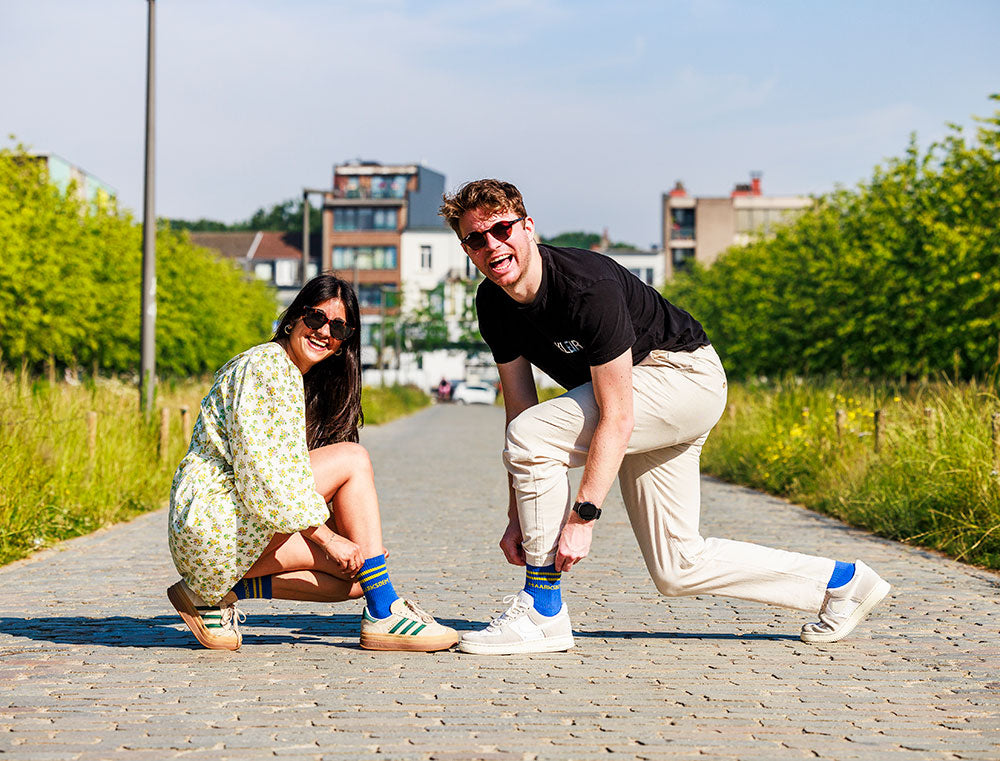 Man en vrouw met sokken met opdruk MAARKSOEM.