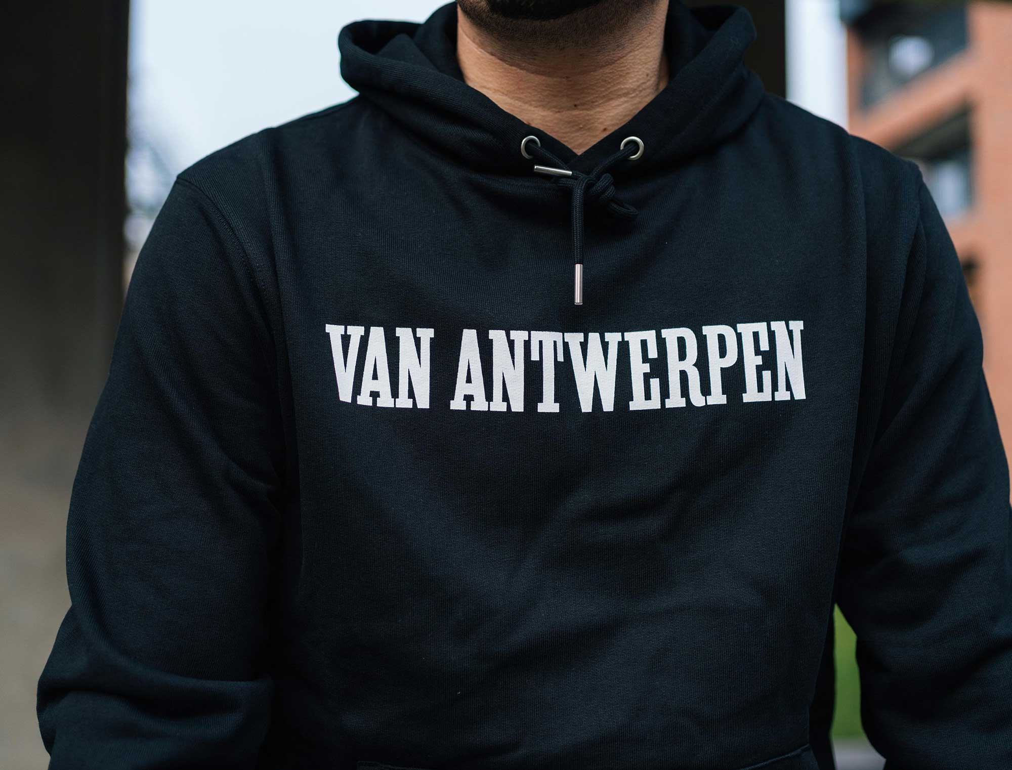 Close-up van een zwarte hoodie met opdruk Van Antwerpen in de typische GVA letters.