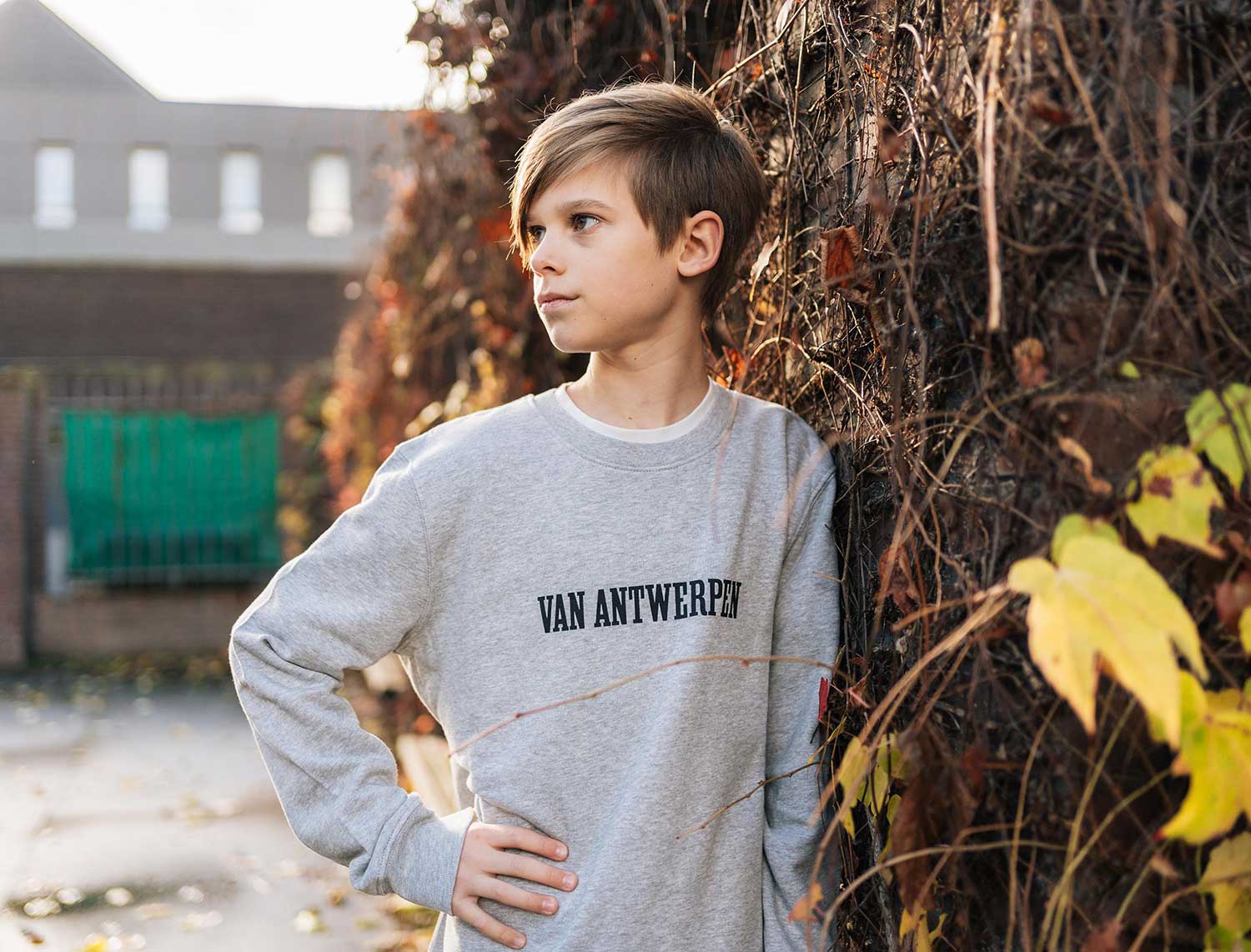 Jongen met een grijze sweater met opdruk Van Antwerpen met typische GVA letters